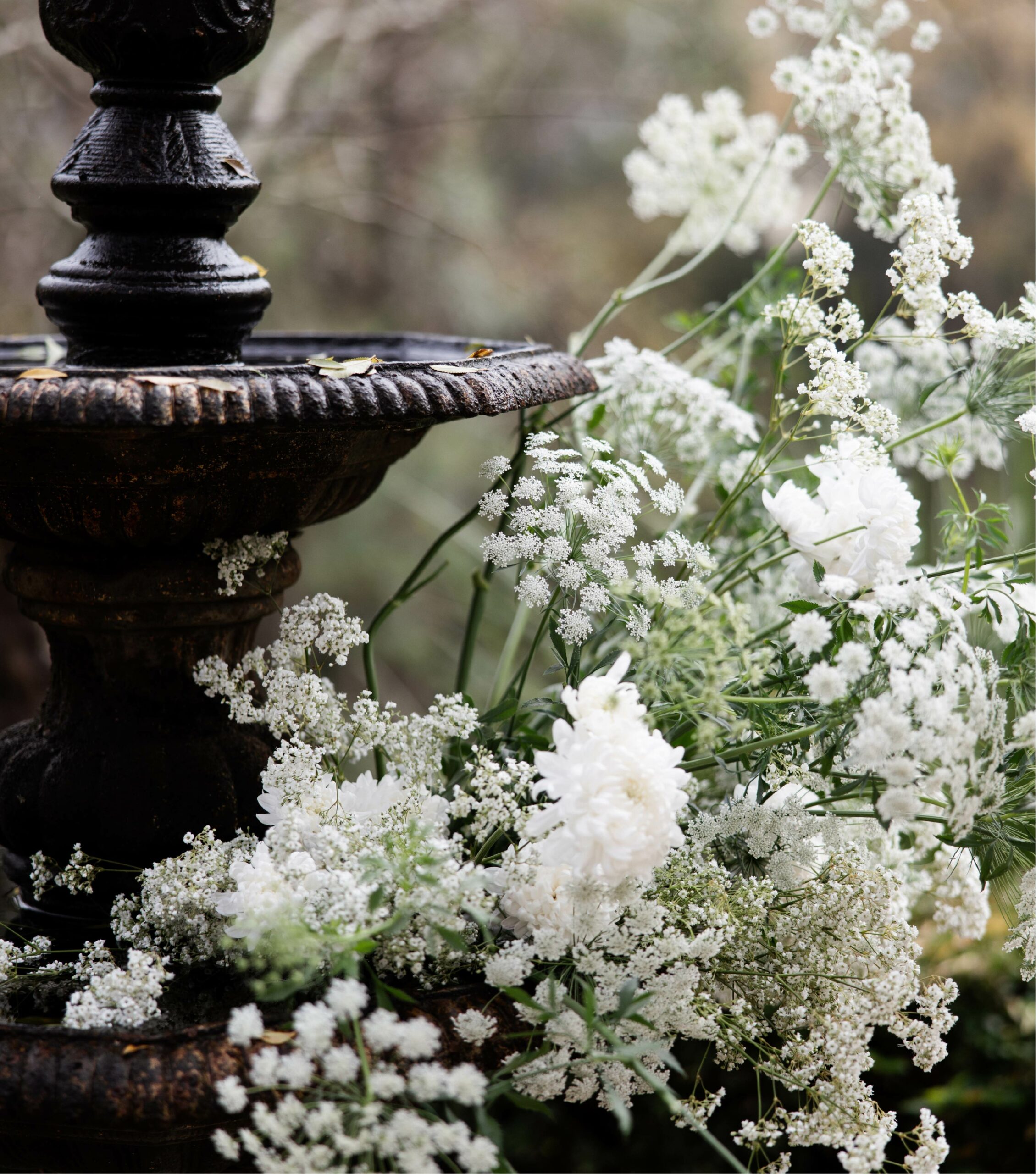 White Florals Next to a Black Water Fountain