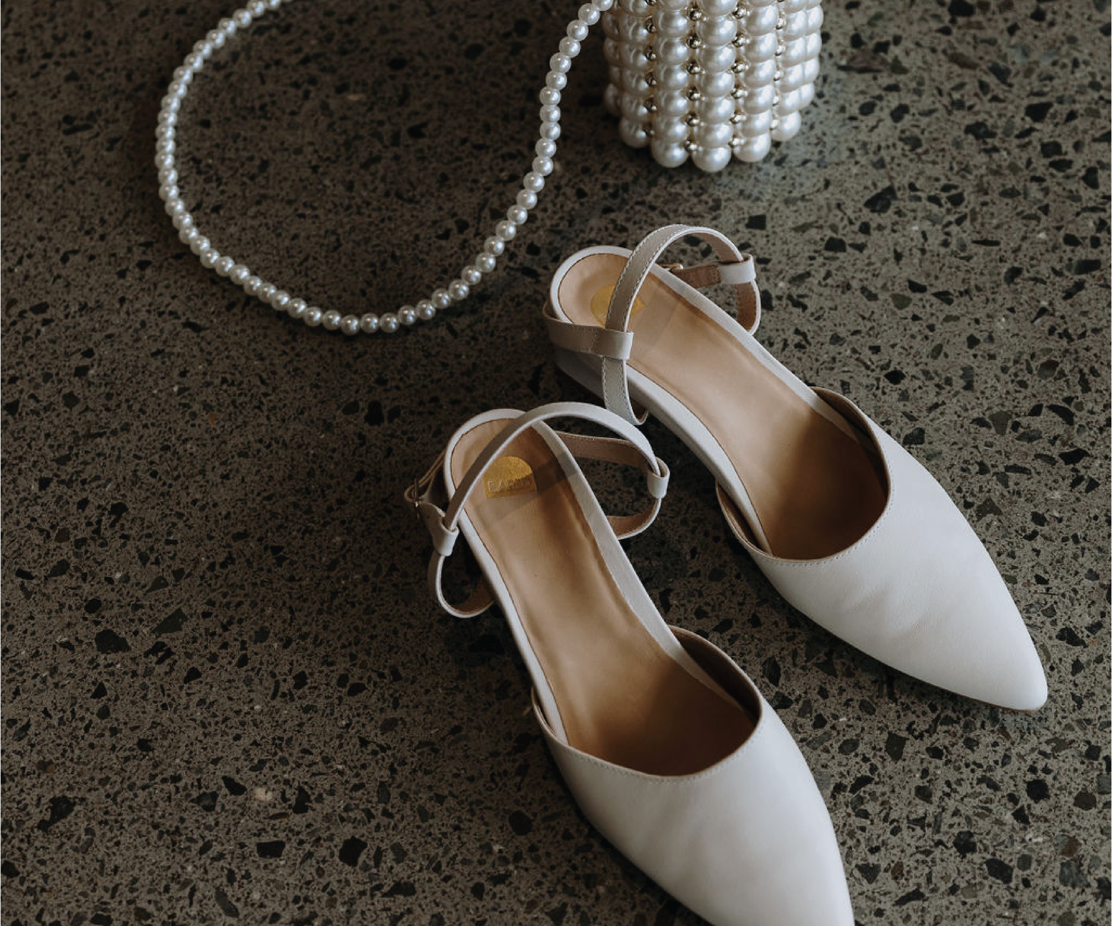 Photo of wedding shoes and pearl bag